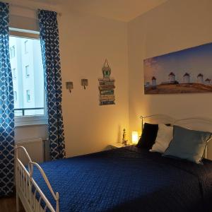 um quarto com uma cama azul e uma janela em Center Firefly Gardens Apartment em Novi Sad