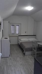 Schlafzimmer mit einem Bett, einem Schreibtisch und einem Tisch in der Unterkunft EMA HOUSE in Zadar