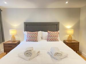 a bedroom with a large white bed with two lamps at Scandic House, 1 Bed Apartments, Sleeps 2, Ulverston in Ulverston