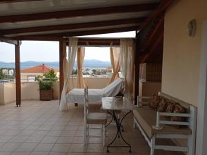 a balcony with a bed and a couch and a table at House with Wonderful View in Lefkandi Chalkidas