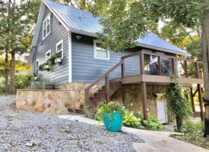 Cette petite maison bleue dispose d'une terrasse couverte et d'un escalier. dans l'établissement Chickamauga River Refuge- River access and Dock!, à Decatur