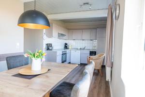 eine Küche und ein Esszimmer mit einem Tisch und Stühlen in der Unterkunft Pellwormer Jensenhof in Pellworm