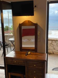 a dresser with a mirror and a television on top at Anastasia Village in Nikiana