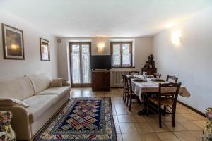 een woonkamer met een bank en een tafel met stoelen bij Casa in un'esclusiva zona di Motta di Sotto in Motta