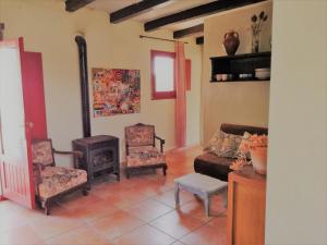 a living room with a couch and chairs and a stove at Casa El Dragonet in Perelló