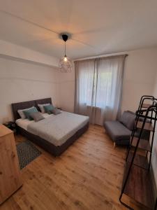 a bedroom with a bed and a couch and a chair at Gemini Suites in Kaštela