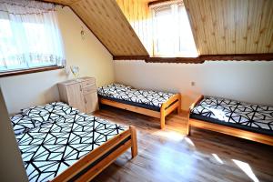 a bedroom with two beds in a room at Chata z Kominkiem - Drozdówka Solina- 6-9-2-2-8-1-3-6-3 in Solina