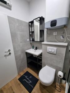 a bathroom with a white toilet and a sink at Gemini Suites in Kaštela +42 photos