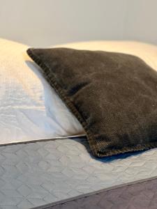 ein braunes Kissen auf dem Bett in der Unterkunft SUNSET APARTMENT: FREE PARKING + BALCONY + NETFLIX in Essen