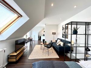 ein Wohnzimmer mit einem blauen Sofa und einem Fenster in der Unterkunft SUNSET APARTMENT: FREE PARKING + BALCONY + NETFLIX in Essen