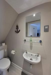 bagno con lavandino, servizi igienici e specchio di An Cnoc Bed & Breakfast a Staffin