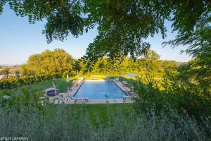 een groot zwembad in een tuin met bomen bij Macchie San Vincenzo - Villa Privata con Piscina e Giardino ad uso esclusivo o camere in Chiusi