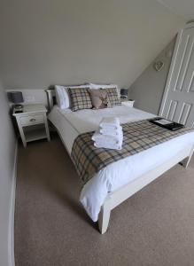 1 dormitorio con 1 cama blanca y 2 mesitas de noche en An Cnoc Bed & Breakfast, en Staffin