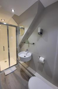 La salle de bains est pourvue d'un lavabo, d'une douche et de toilettes. dans l'établissement An Cnoc Bed & Breakfast, à Staffin