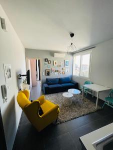 a living room with a blue couch and yellow chairs at City Life Apartments #1 in Ioannina