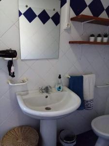 a white bathroom with a sink and a mirror at Ribeira da Praia House in Vila Franca do Campo +31 photos