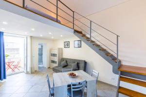 a living room with a table and a staircase at Il Vefio by Tizzano House in Procida