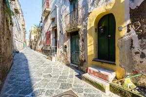an alley in an old building with a green door at Il Vefio by Tizzano House in Procida