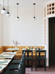 een eetkamer met tafels en stoelen en een witte muur bij Hotel Orphée - Orso Hotels in Parijs