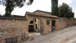 a dog sitting in front of a brick building at La Terrazza di Spello in Spello