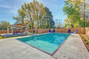 una piscina en un patio trasero con una valla de madera en Gulf Breeze Home with Pool, Grill and Fire Pit, en Gulf Breeze