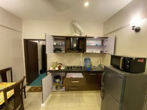 a small kitchen with a stove and a refrigerator at "Service Apartments Karachi" Ocean View 2 Bed Room Apt in Karachi