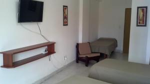 a room with a tv and a bed and a chair at Premier in Santiago del Estero