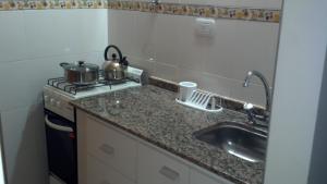 a small kitchen with a sink and a stove at Premier in Santiago del Estero