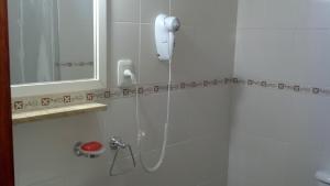 a shower in a bathroom with a phone on the wall at Premier in Santiago del Estero