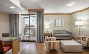 巴西利亚Brasil 21 Convention Affiliated by Meliá的带沙发、桌子和椅子的客厅