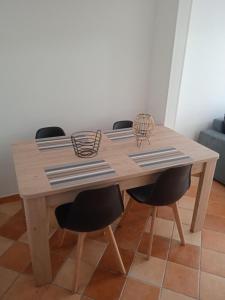 una mesa de madera con dos sillas negras alrededor en La Terrasse en Mers-les-Bains