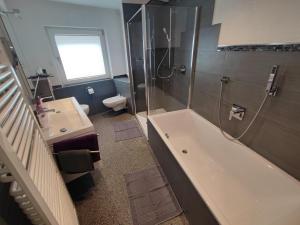 a bathroom with a tub and a sink and a toilet at Ferienhaus Quell in Sankt Martin