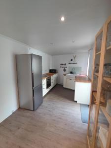 a kitchen with a stainless steel refrigerator and white cabinets at Ferienhaus Quell in Sankt Martin