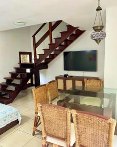 ein Esszimmer mit einem Glastisch und Korbstühlen in der Unterkunft Apartamentos no Solar Pipa in Pipa