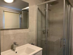 a bathroom with a sink and a glass shower at Kustverhuur, Groede, Paarlhof 17 in Groede