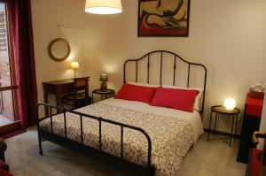 Un dormitorio con una cama con almohadas rojas. en B&B il rosso e il nero, en Zafferana Etnea