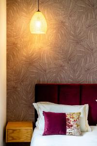 um quarto com uma cama com uma almofada roxa e um candeeiro em Mouzinho 129 - Medronheiro & Oliveira no Porto