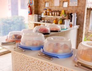 a counter with food in plastic containers on it at Pousada Alquimia in Jericoacoara