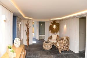 sala de estar con sofá y silla en The Originals Boutique La Villa Ouest & Spa, en Saint-Palais-sur-Mer