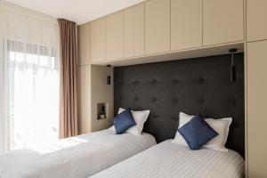 1 dormitorio con 2 camas y almohadas azules en Villa Magna luxury apartments, en Murter