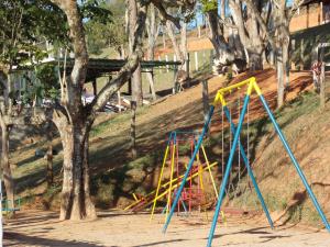 un parque infantil con postes azules y amarillos junto a un árbol en Recanto Apoena, en Santa Isabel