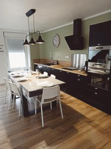 uma cozinha com mesa e cadeiras num quarto em "Mont 1er Pas" proche Mont St Michel em Pontorson