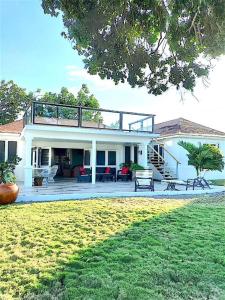 una grande casa bianca con balcone e cortile di Silver Sands Sea Lili a Silver Sands