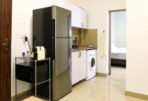 a kitchen with a refrigerator and a washing machine at Paris Square Apartments Downtown in Haifa