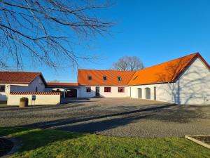 ein orangefarbenes Dach auf einem weißen Gebäude mit Auffahrt in der Unterkunft Lovely room, easy access to E45 highway in Rask Mølle