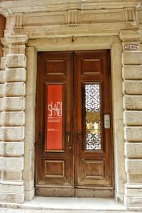 uma porta de madeira num edifício de pedra com uma placa em Foresteria Levi em Veneza