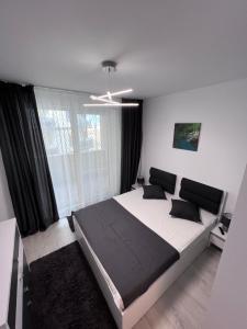 - une chambre avec un grand lit et une fenêtre dans l'établissement Fiesta Apartments, à Mamaia Nord – Năvodari
