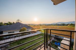a view from the balcony of a home with the sunset at Kaze House in Chiang Rai
