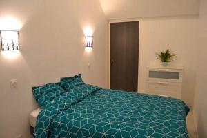 1 dormitorio con 1 cama con edredón azul en Ty cocooning, en Kerlouan