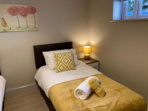 a bedroom with a bed with a towel on it at Garfield Cottage in Kettering